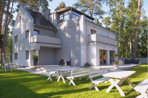 a white house with picnic tables in the grass at Willa Cicho Sza in Pobierowo
