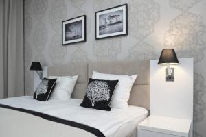 a bedroom with a bed with two black and white pillows at Willa Cicho Sza in Pobierowo