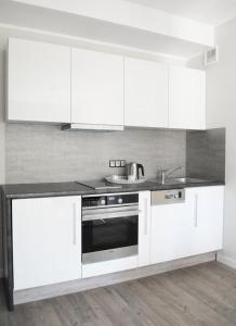 a kitchen with white cabinets and a stainless steel oven at Willa Cicho Sza in Pobierowo