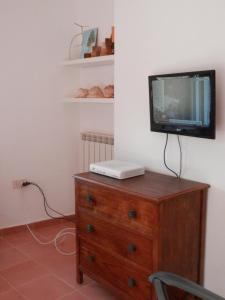 a tv sitting on top of a wooden dresser at Dèpendance Argentario in Porto Santo Stefano +14 photos
