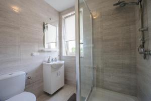 een badkamer met een douche, een toilet en een wastafel bij Apartamenty Crystal in Ciechocinek