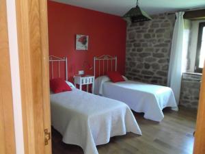 2 camas en una habitación con paredes rojas en La Escuelona en Pejanda