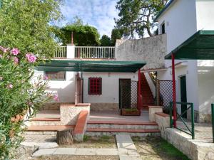 a white house with a red door and stairs at Camping Village Vieste Marina in Vieste