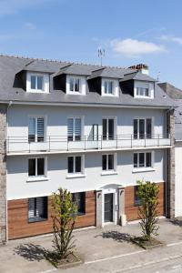 una vista exterior de un edificio blanco con detalles en madera en Résidence Maréchal Leclerc en Laval