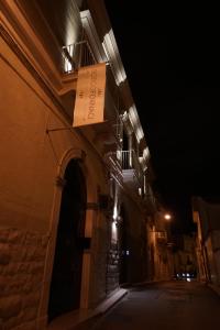 um sinal na lateral de um edifício à noite em B&B BORGO FORNACI em Andria