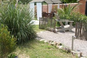 een stoel in een tuin met een hek bij Chambres d´Hôtes Belle Rivière in Salernes