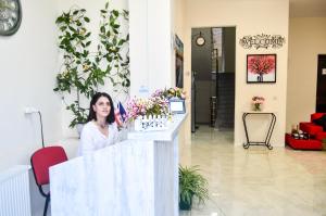 a woman standing behind a counter in a flower shop at Fazis Hotel in Poti