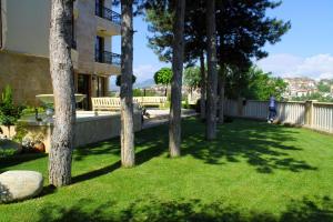 a group of trees in a yard with a building at Garden Guest House in Sandanski