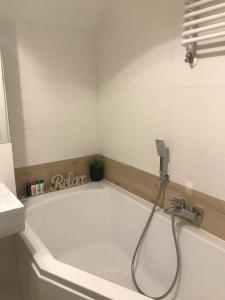 uma banheira com chuveiro na casa de banho em Black Rose APARTAMENT Targi 3 km, F-ry Vat em Kielce