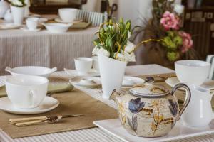 a table with a tea kettle and cups and flowers at B&B La Zolla in Impruneta +65 photos