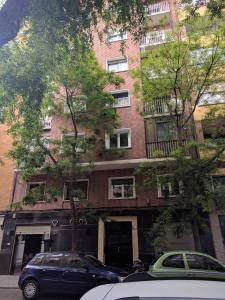 マドリードにあるGran Apartamento Cerca de Atochaのレンガ造りの建物の前に停車する青い車