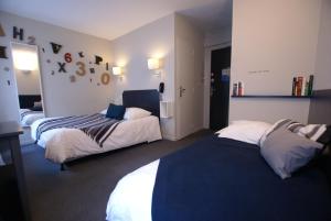 a hotel room with two beds in a room at Hotel de la Placette Barcelonnette in Barcelonnette