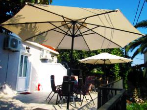 einen Tisch und Stühle unter einem Sonnenschirm auf einer Terrasse in der Unterkunft Apartments Palma Ragusa in Dubrovnik