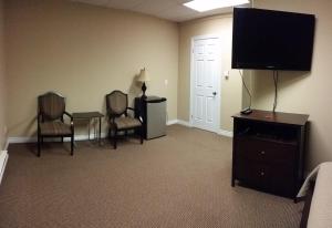 a living room with two chairs and a flat screen tv at Riverview Suites in Clarenville