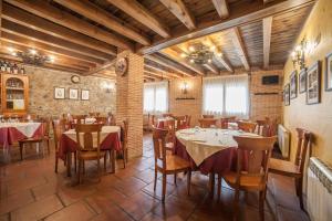 un ristorante con tavoli e sedie in una stanza di La Casona del Herrero a Navaleno