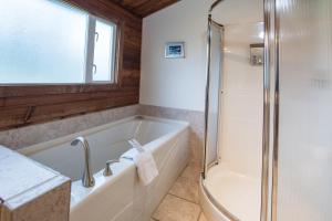 uma casa de banho com banheira e chuveiro em Ocean Resort em Oyster Bay