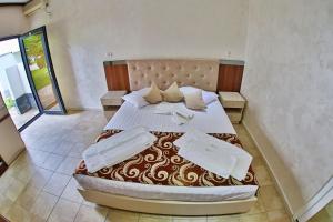 Postel nebo postele na pokoji v ubytování Jijo's Hotel