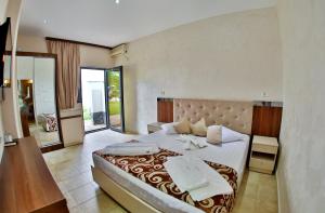 Postel nebo postele na pokoji v ubytování Jijo's Hotel