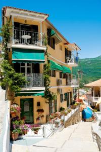 a yellow building with tables and chairs in front of it at Marina's House in Parga