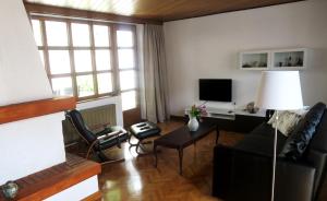 a living room with a couch and a tv at Hiša Kala in Kobarid
