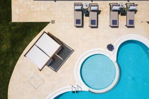 an overhead view of a swimming pool with a table and chairs at Aelia Residence, a luxurious pampering experience, By ThinkVilla in Skaleta