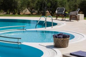 a wicker basket sitting next to a swimming pool at Aelia Residence, a luxurious pampering experience, By ThinkVilla in Skaleta