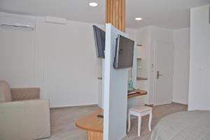 a living room with a bed and a tv in a room at Christina Beach Hotel in Chania Town