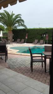 - une piscine avec des chaises, une table, une table et des chaises dans l'établissement Bella Grecia, à Chaniotis