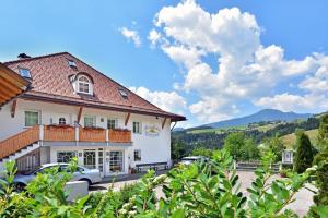 ein großes weißes Gebäude mit davor geparkt in der Unterkunft Residence Treyer in Terenten