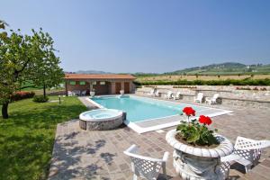 a swimming pool in a yard with chairs and a house at Tenuta Terensano in Monleale