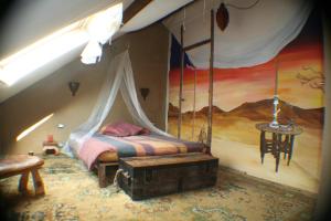 1 dormitorio con 1 cama en una habitación con una pintura en B&B Le Relais de Charlinette, en Boignée
