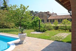 a plant in a pot sitting next to a swimming pool at Tenuta Terensano in Monleale