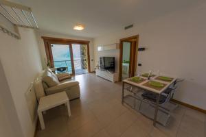 een woonkamer met een bank en een tafel bij Residence degli Oleandri 4B in Argegno