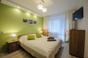 a bedroom with a large bed and a flat screen tv at Apartamenty Crystal in Ciechocinek