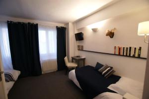 a hotel room with a bed and a desk at Hotel de la Placette Barcelonnette in Barcelonnette