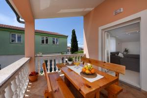 a balcony with a wooden table with fruit on it at Apartment Monika - Private terrace & Parking in Zadar