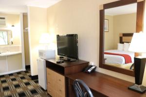 a hotel room with a television and a bed at Castlewood Inn in Maggie Valley