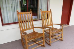 duas cadeiras de madeira sentadas em frente a uma janela em Castlewood Inn em Maggie Valley
