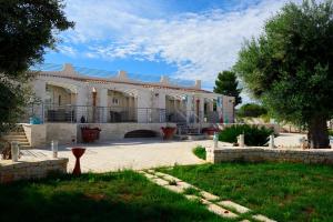 a large house with a porch and a yard at Casale Porto Contessa in Polignano a Mare