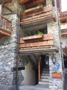 dom z drewnianymi schodami i roślinami na nim w obiekcie La Cincia w mieście Morgex