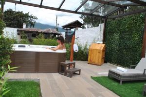 une femme assise dans une baignoire dans un jardin dans l'établissement Villa Mimi, à Otavalo