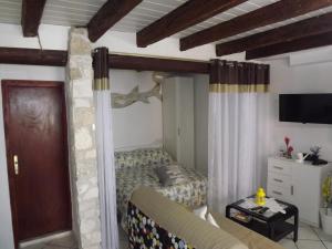a bedroom with a bed and a couch and a tv at Apartment The old house in Vrsar