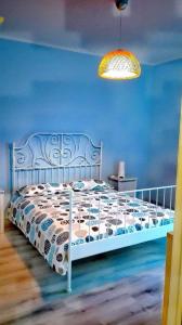 1 dormitorio con cama blanca y pared azul en Tra MENTA e MELIGA, en Carignano