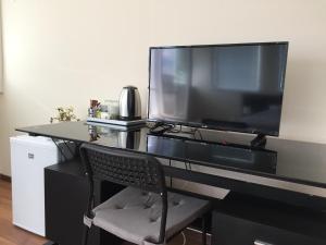 a black desk with a television and a chair at Rooftop Oscar Rooms in Sofia