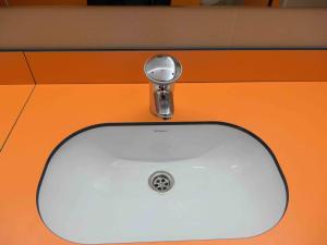 a white sink with a faucet on an orange counter at Alberg Olot Xanascat in Olot