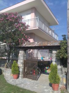 a house with a balcony and plants in front of it at Patra Rooms Skala Prinou in Prinos