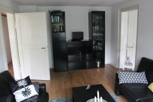 a living room with a black couch and a black cabinet at Zuhause mit nordischen Charme in Clausthal-Zellerfeld