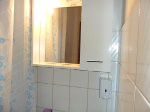 La salle de bains est pourvue d'un cabinet de toilette et d'un miroir. dans l'établissement Sobe u kucanstvu MBM, à Međugorje