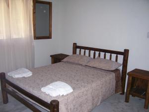 a bedroom with a bed with two towels on it at Finca Puesta del sol in San Agustín de Valle Fértil +21 photos