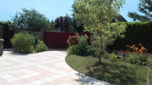 Saint-Aubin-lès-ElbeufにあるLa maisonnette du Jardin Fleuriのフェンス付きの庭園、パティオ